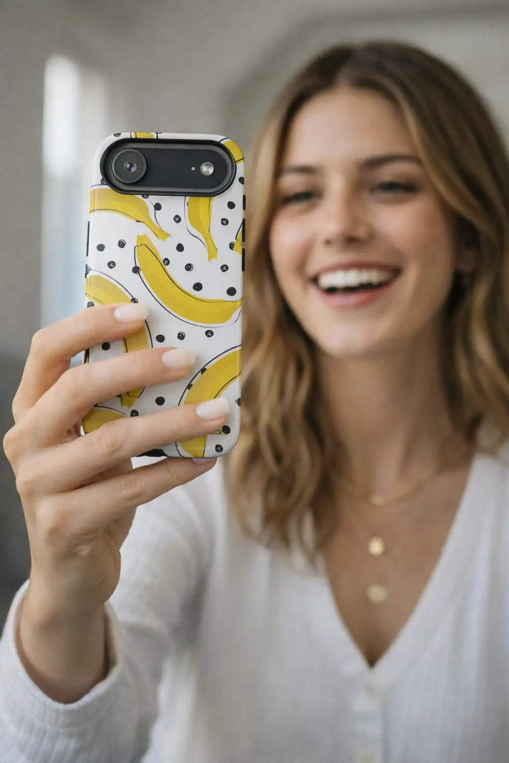Yellow banana-patterned phone case with black polka dots on a white background.